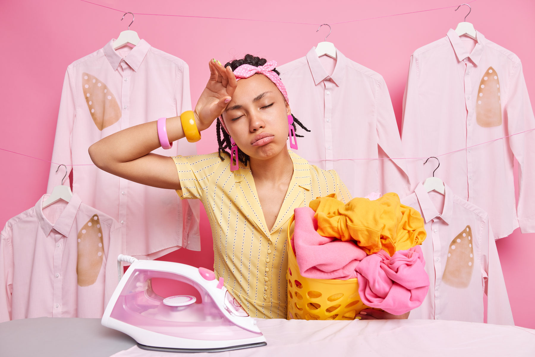 femme montrant des signes de fatigue derrière une table à repasser